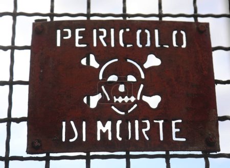 Téléchargez les photos : Signe de fer avec l'écriture en italien Pericolo di Morte qui signifie danger de mort si l'on passe la barrière de protection - en image libre de droit