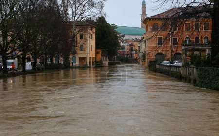 Overflowing Retrone River floods Vicenza city in Northern Italy after heavy rain and ancient Tower in background