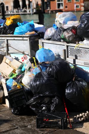 Varias bolsas de basura en un contenedor sobrecargado en la ciudad