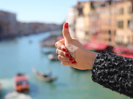 Daumen hoch ok Zeichen der Hand eines jungen Mädchens mit Nägeln mit rotem Nagellack und Grand Canal in Venedig