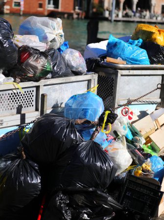 Plusieurs sacs poubelles de déchets solides dans une benne à ordures en ville