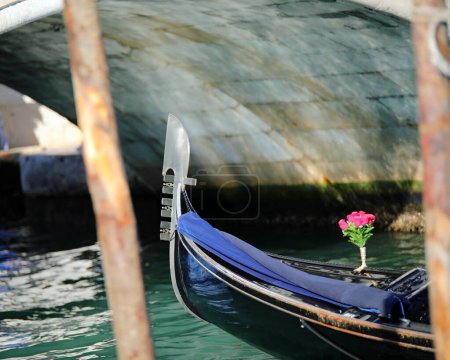 Arco de góndola el tradicional barco veneciano para el transporte de turistas y maceta de flores en el gran canal