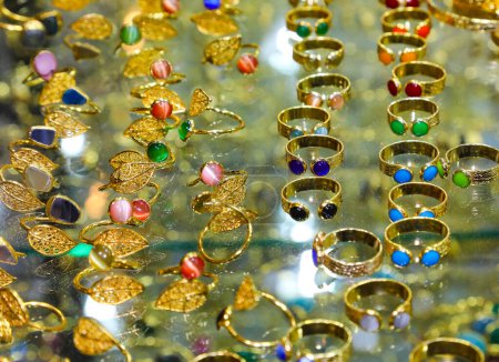 Photo for Golden rings with colored stones for sale in the jewelry store window of the shopping center - Royalty Free Image