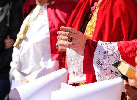 Hand des Bischofs in klerikaler Kleidung segnet vor ihm stehende Nonnen