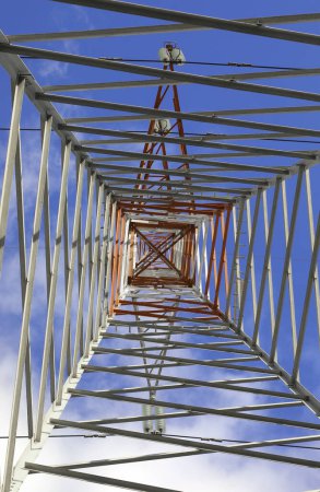 pylône haut avec câbles haute tension pour le transport d'électricité et de nuages blancs sur le ciel bleu