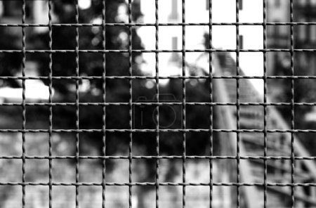 Foto de Rejilla metálica protectora con tonos oscuros y un efecto blanco y negro muy dramático - Imagen libre de derechos