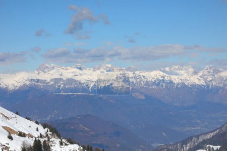 Breathtaking panorama of the European Alps mountain range in winter with snow-capped peaks  with blue sky