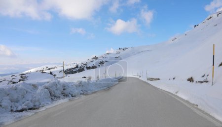 dangerous very slippery mountain road with ice sheet after snowfall in winter