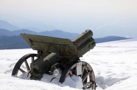 Uralte grüne Kanone aus dem Ersten Weltkrieg im Winter komplett vom Schnee überflutet