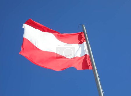 Téléchargez les photos : Drapeau autrichien à rayures rouges et blanches sur fond bleu ciel à Vienne Autriche - en image libre de droit