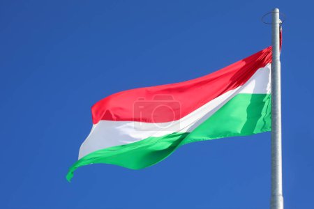 Hungarian red white and green striped flag of Hungary in Budapest city with blue sky