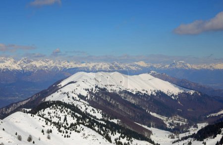 Breathtaking panorama of the European Alps mountain range in winter with snow-capped peaks without people with blue sky