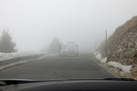 Armaturenbrett des Autos während der Fahrt auf Bergstraße mit schlechter Sicht aufgrund von Nebel
