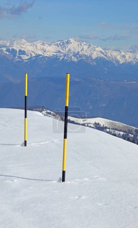 Marcadores de nieve negros y amarillos también llamados estacas de nieve en la carretera en invierno