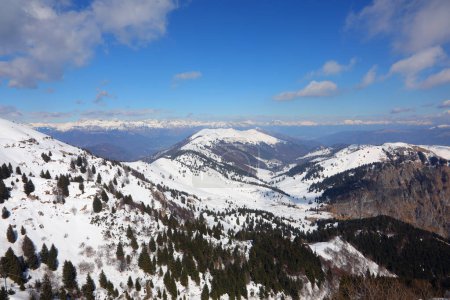Breathtaking panorama of the European Alps mountain range in winter with snow-capped peaks  with blue sky