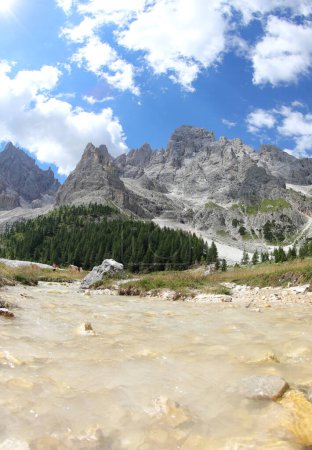 Bach mit frischem Quellwasser und Bergkette im Hintergrund