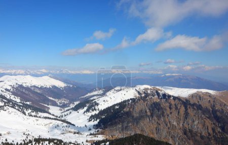 Breathtaking natural landscape of the European Alps in northern Italy with snow-capped mountain peaks and blue sky in winter