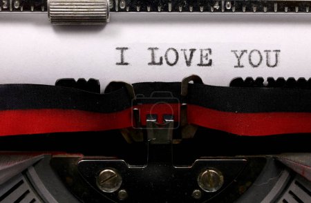 uppercase I LOVE YOU text typed in black ink on white paper with an old typewriter