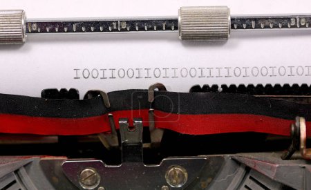 Séquence binaire de zéros et un écrit à l'encre noire sur un papier blanc avec une vieille machine à écrire