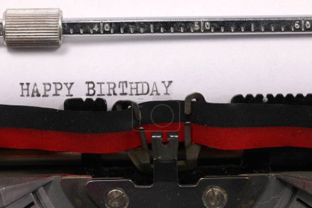 Vintage typewriter with black ink Happy Birthday message on white paper