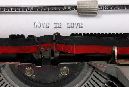 Téléchargez les photos : L'AMOUR EST AMOUR manuscrit à l'encre noire sur papier blanc avec une machine à écrire antique symbolisant l'amour universel et illimité - en image libre de droit