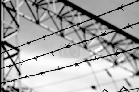 Téléchargez les photos : Zone restreinte haute clôture avec fil barbelé et dramatique effet noir et blanc - en image libre de droit