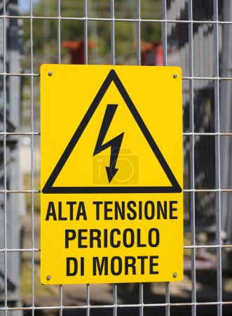 Firme en la cerca de la central eléctrica con el texto grande en italiano que significa Peligro de muerte de alto voltaje para evitar el riesgo de electrocución a las personas