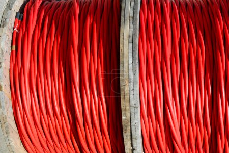 Enrouleurs de câbles électriques rouges pour haute tension pendant l'installation de l'infrastructure électrique
