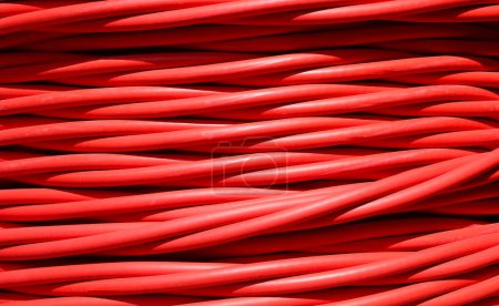 Photo for Close-up of thick red electrical cable for transporting high-voltage electricity from power plant to substations - Royalty Free Image