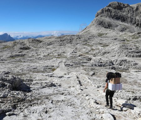 Téléchargez les photos : Porteur en haut de la montagne sur le sentier pour livrer des marchandises aux collectivités éloignées - en image libre de droit