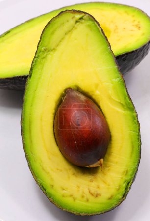 green avocado seed from a ripe tropical fruit cut in half