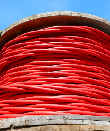 Photo for Large red high voltage electrical cable reel for transporting electricity from power plant - Royalty Free Image