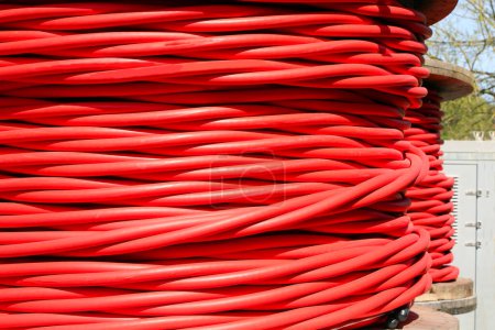 large red reel of high voltage electrical cable used for transporting electricity from a power plant