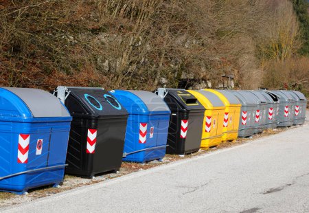 row of waste and recycling bins by the roadside without people