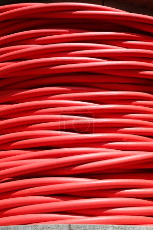 Photo for Large red reel of high voltage electrical cable used for transporting electricity from a power plant - Royalty Free Image