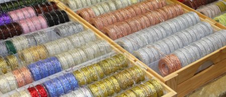 Téléchargez les photos : De nombreux rubans de tissu brillant en argent doré couleur bleu cuivre à vendre dans la boutique de passe-temps - en image libre de droit