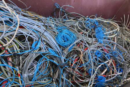 large quantity of used electrical wires in the recycling container for the recycling of material and copper to safeguard the environment