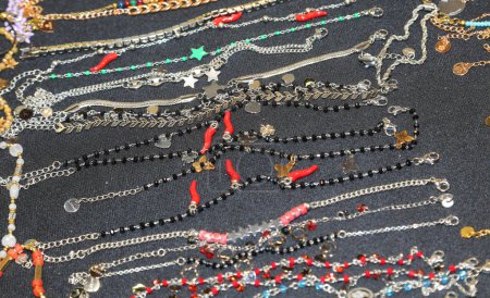 many necklaces and bracelets and anklets some with red chili pepper in a jewelry stall in the shopping center