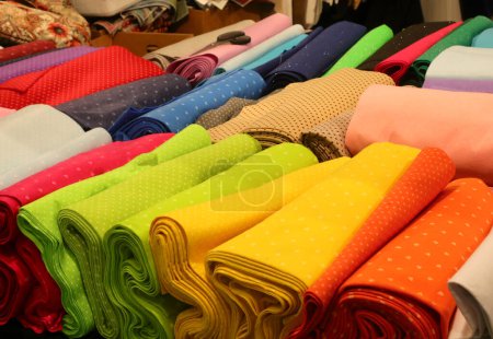 Téléchargez les photos : De nombreux tissus colorés en coton et feutre à vendre sur le comptoir dans la boutique de couture et de draperie - en image libre de droit