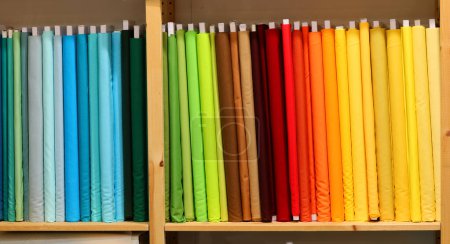 Téléchargez les photos : Étagère d'exposition dans une usine textile débordant d'échantillons de tissu coloré pour les tailleurs à acheter - en image libre de droit