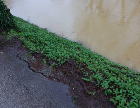 Téléchargez les photos : Effondrement de l'asphalte de la route et a de grandes fissures en raison de la montée des eaux d'inondation après des pluies torrentielles - en image libre de droit