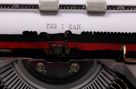 Schreibmaschine JA ICH KANN auf leerem Blatt mit Vintage-Schreibmaschine, die die Möglichkeit symbolisiert, immer erfolgreich zu sein