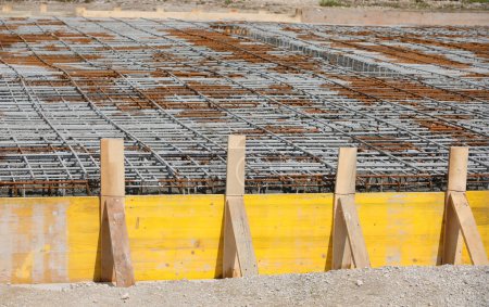 Téléchargez les photos : Coffrage de construction fait avec des planches lors de la pose de ciment pour faire fondation du bâtiment sur le chantier de construction sans travailleurs - en image libre de droit