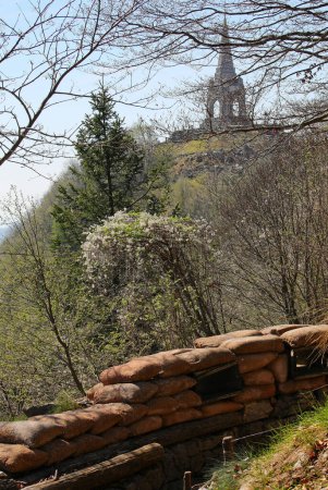 tranchée étroite creusée dans le sol et vue sur l'ossuaire du Monte Cimone en Italie