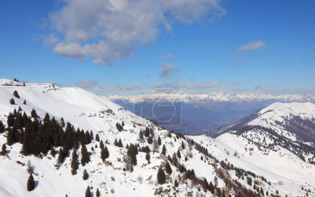 Breathtaking natural landscape of the Alps in northern Italy with snow-capped mountain peaks and blue sky in winter