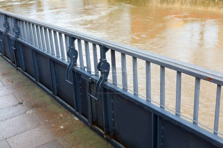 Mobile flood barrier for bridge railing to protect against overflowing river in city
