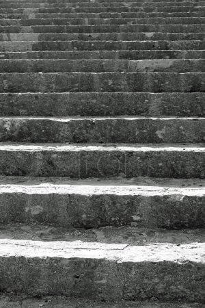 very long staircase with gray stone steps that rises towards infinity