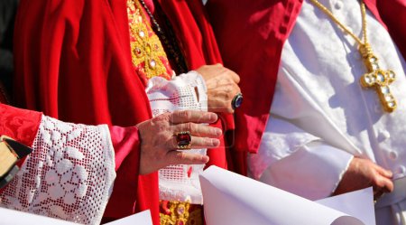 Téléchargez les photos : Main du prêtre avec une bague voyante avec pierre précieuse lors de la bénédiction des fidèles - en image libre de droit