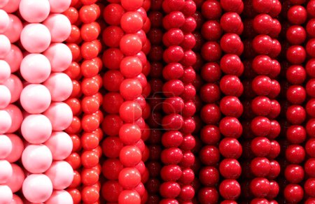 Hintergrund aus bunten Halsketten aus roten und rosa Perlen im Geschäft für Modeaccessoires