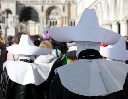 procesión religiosa con monjas con túnicas y grandes sombreros blancos vistos desde atrás